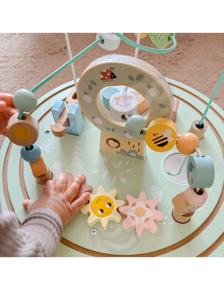Enfant debout devant la table d'activités en bois