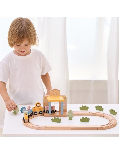 Enfant faisant rouler les wagons sur le circuit de train