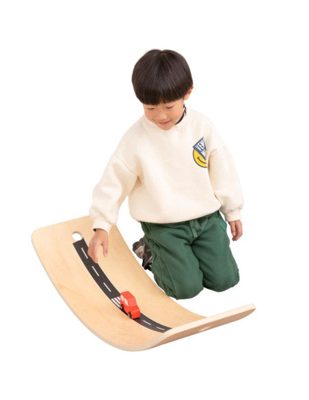 Enfant jouant avec une voiture sur la planche d'équilibre Viga